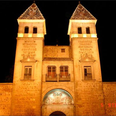 Vista frontal de la Puerta Bisagra en Toledo iluminada artísticamente